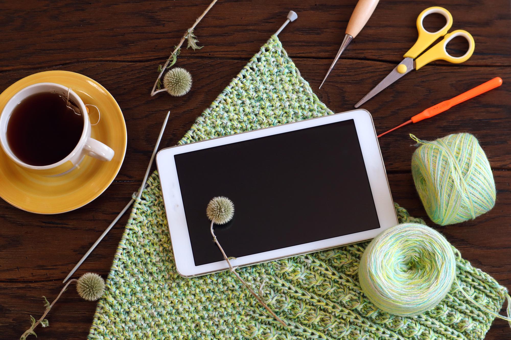 Workshop table with threads and digital pattern tablet
